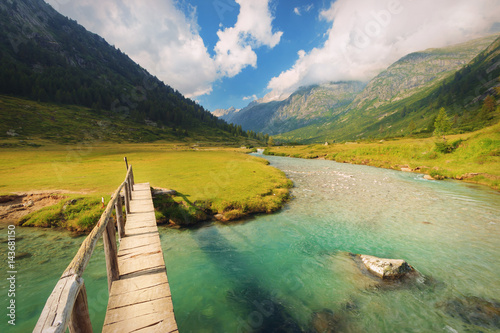 Footbridge over the Chiese river and in the National Park of Adamello Brenta from the Val di Fumo. Trentino Alto Adige, Italy photo