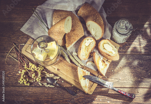 French appetizing baguette with sesame, natural butter, butter sandwiches. Food composition on a wooden background. Selective focus.  Top view