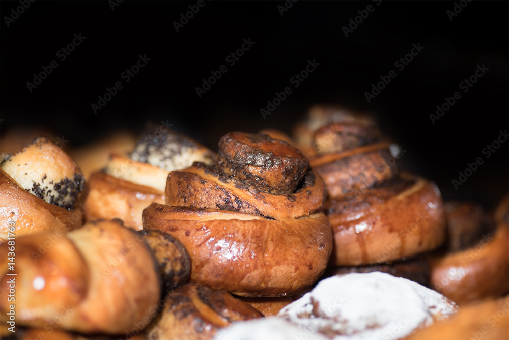 bread (buns) with poppy seeds on a black background 