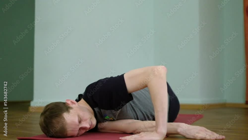 A man yoga makes a healthy stretching in the studio A man yoga makes a healthy stretching in the studio