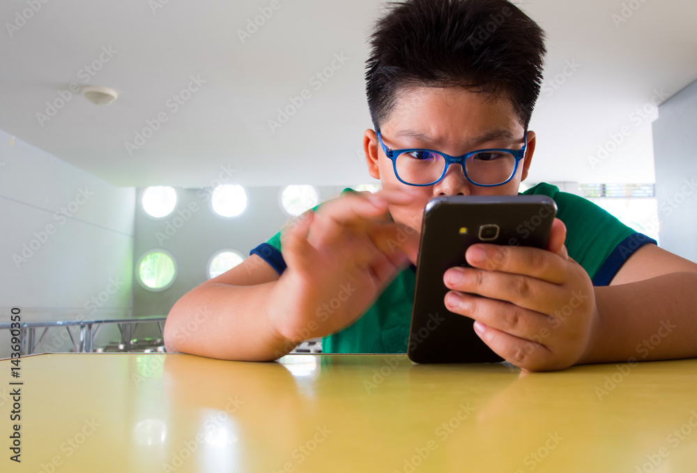 Serious boy playing on smartphone