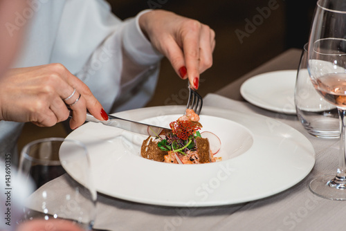 woman is preparing to eat delicious salmon salad in a restaurant. small portion