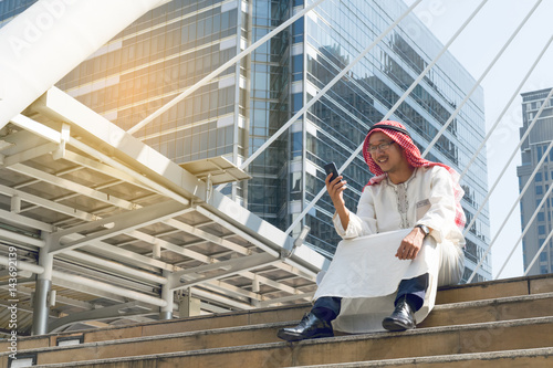 Arab businessman messaging on a mobile phone in the city