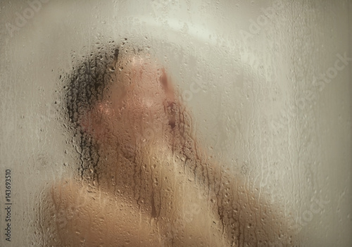 женщина в душевой кабине и капли воды на стекле