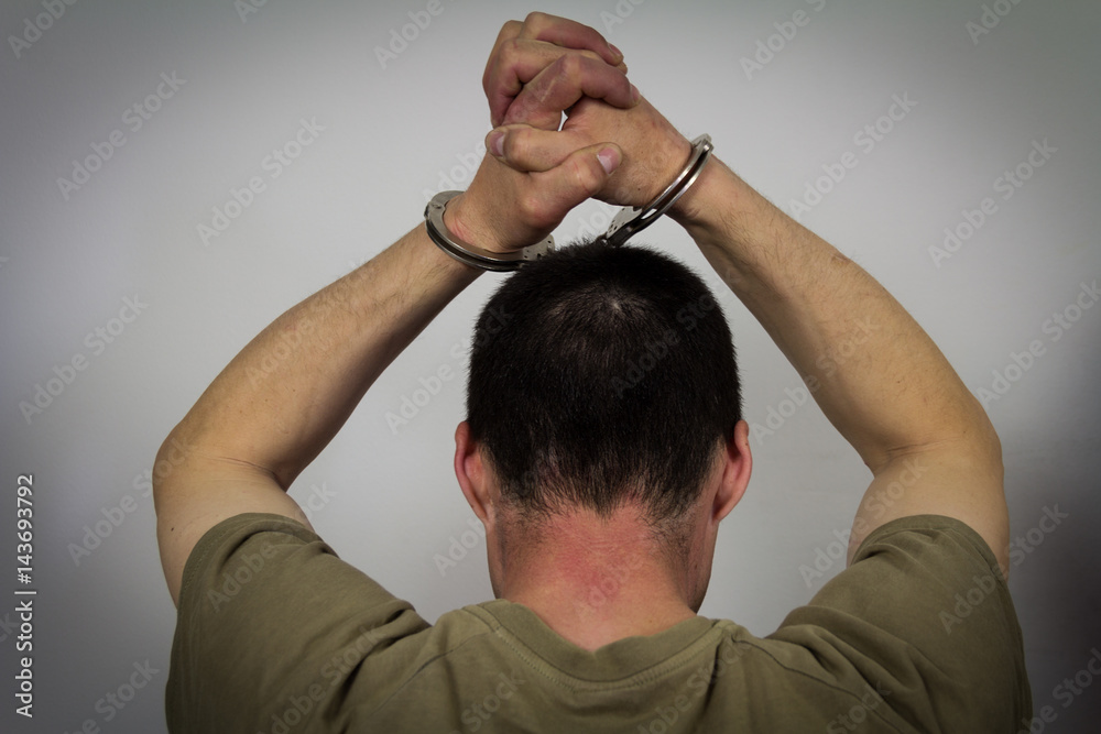 Obraz premium The arrested criminal handcuffed over his head