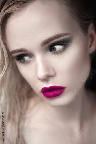 Portrait of beautiful girl model with pink lips and blue eyes with leather belt on her neck, fresh clean highlighted skin. Fashion retouched close up shot. Sad depressed mood