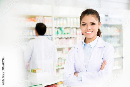 Smiling asian woman pharmacist in pharmacy