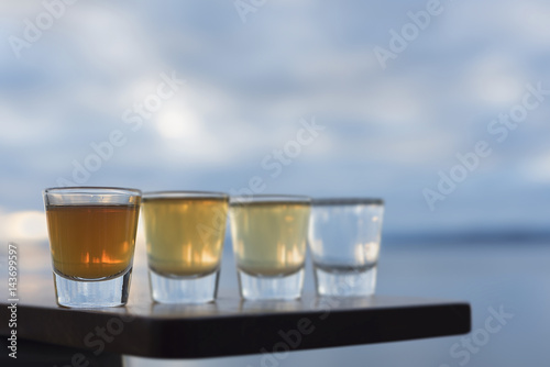 Close up four types of tequila on outside seaside deck