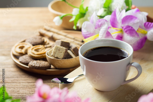 black coffee in white cup with cookie and dessert