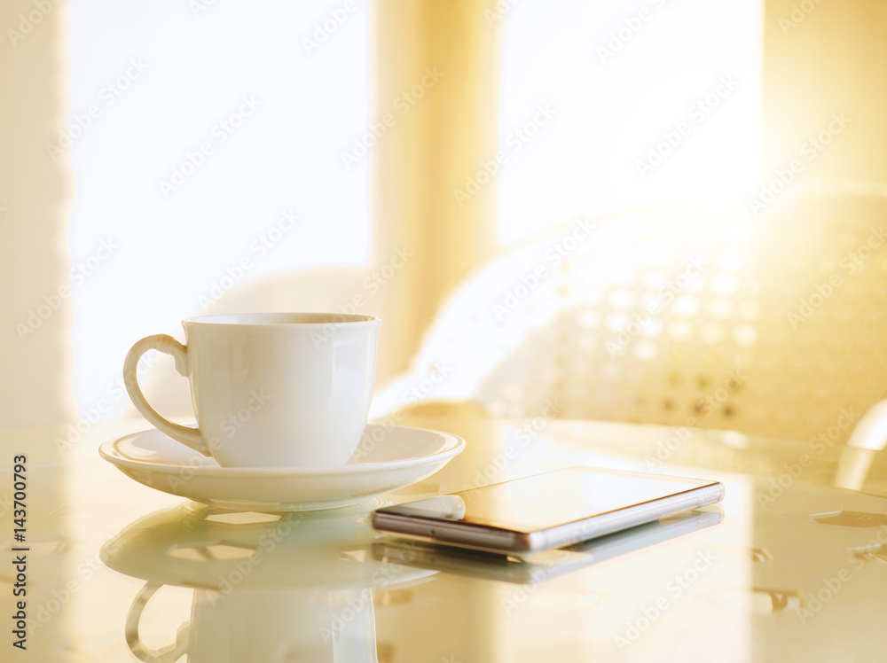 Coffee cup on table and smartphone with sunlight in morning Coffee cup on table and smartphone with sunlight in morning