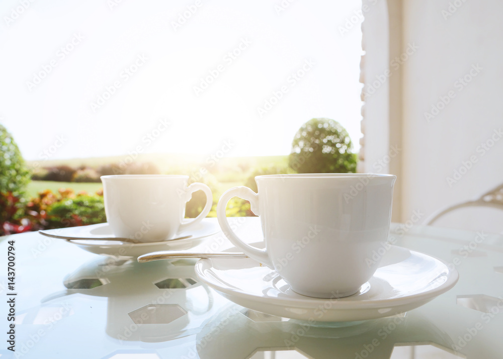 Coffee cup on table against nature background with sunlight Coffee cup on table against nature background with sunlight