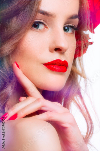 Portret of Beautiful fashion Woman with red lips and nails.Roses on hair.