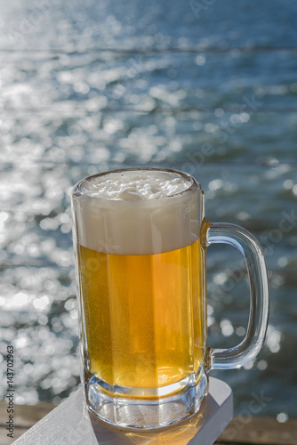 Mug of beer on seaside deck