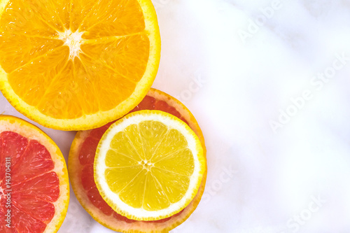 Lemon  orange  and grapefruit slices on white marble