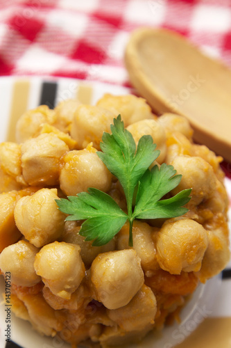 Cooked chickpeas on wooden background and red tablecloth