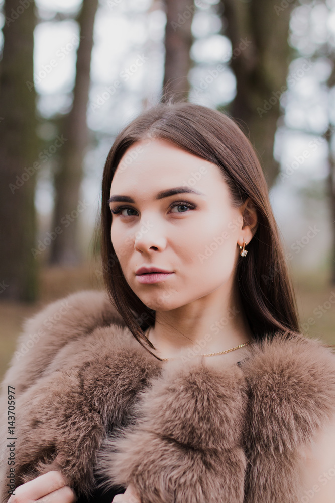 Portrait of a very beautiful girl in a forest dressed in fur Portrait of a very beautiful girl in a forest dressed in fur