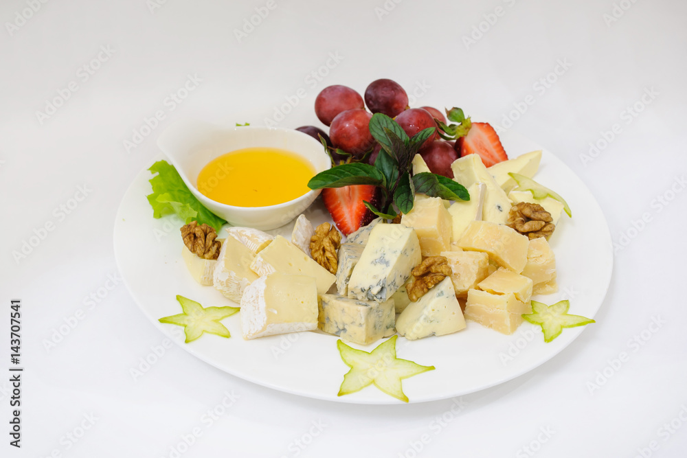 Assorted cheeses on white plate Assorted cheeses on white plate