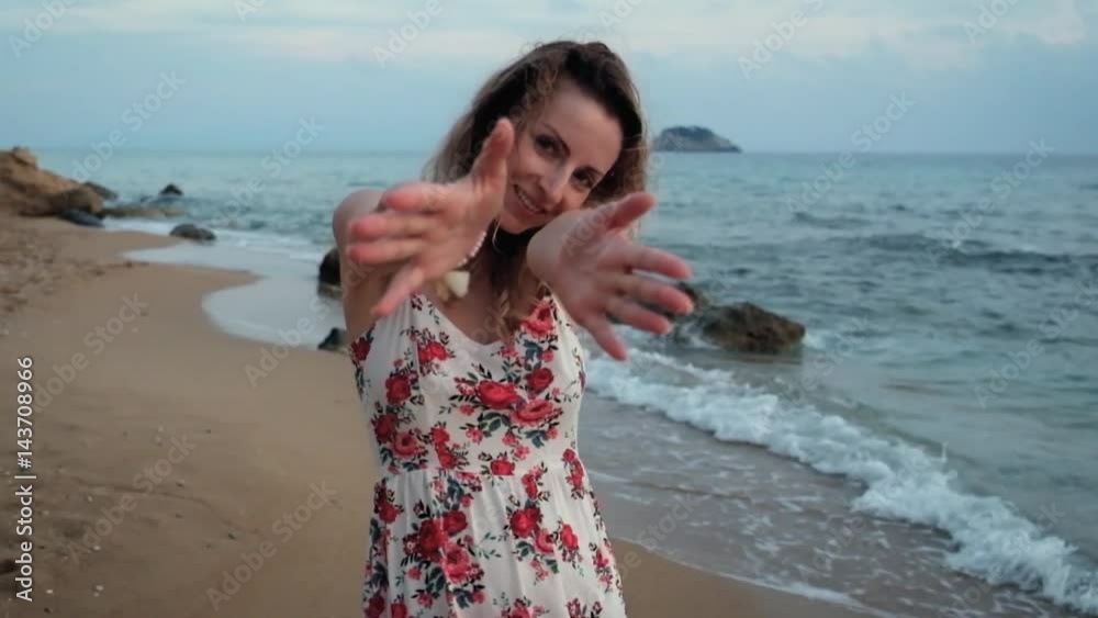 Young beautiful smiling girl walking on beach at sunset Young beautiful smiling girl walking on beach at sunset