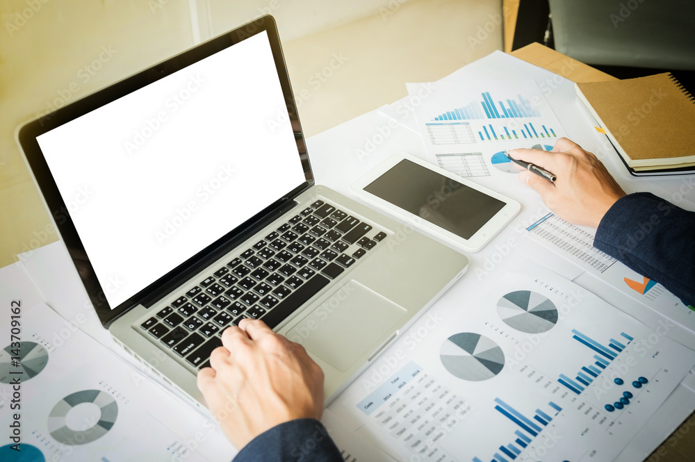 Image of business, businessman working with laptop, tablet and financial document data graph on table in office. Image of business, businessman working with laptop, tablet and financial document data graph on table in office.