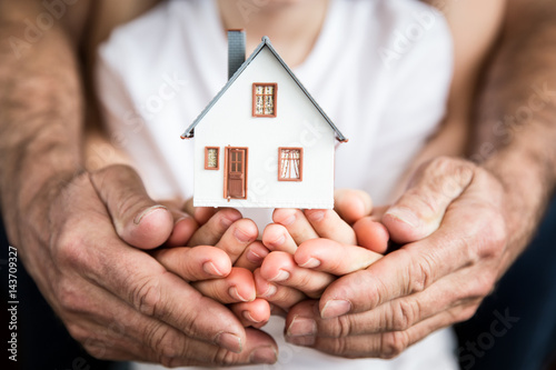 Family holding house in hands