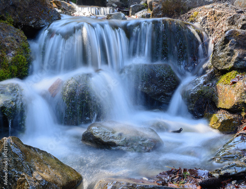 Sch  ner idyllischer Wasserfall mit Felsen im Wald