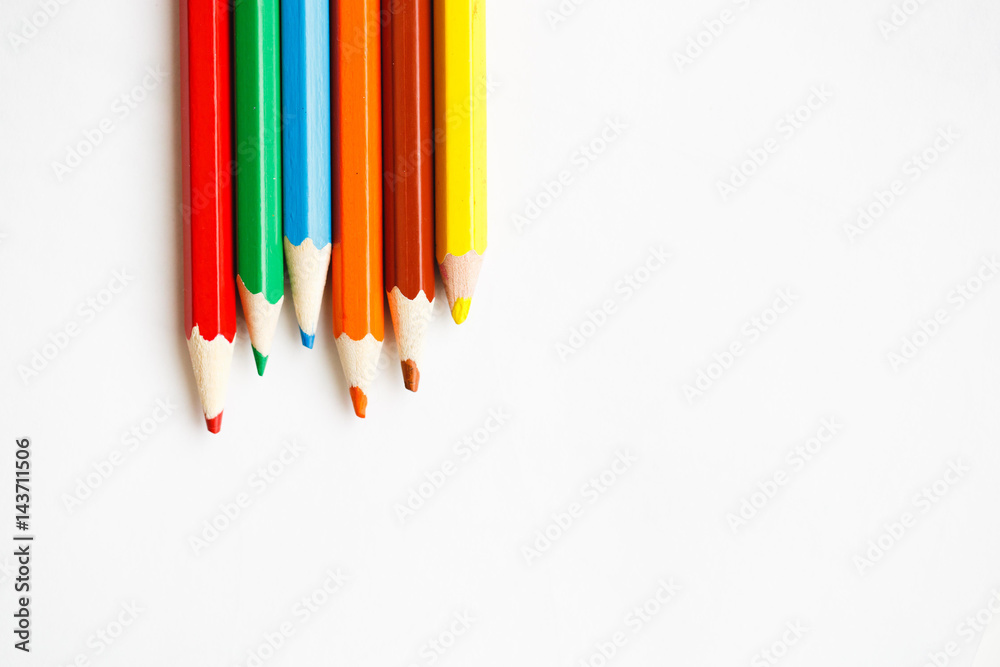 Multicolored pencils lying on a white table