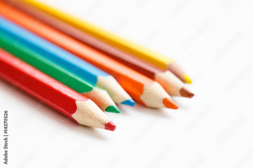 Multicolored pencils lying on a white table Multicolored pencils lying on a white table