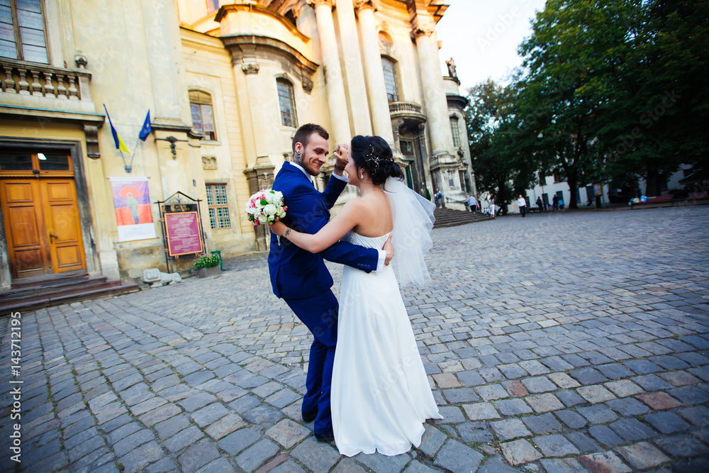 Naklejka premium Bride dancing and hugging on the street