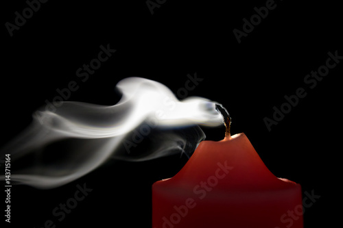 Smoke from a red candle on a black background