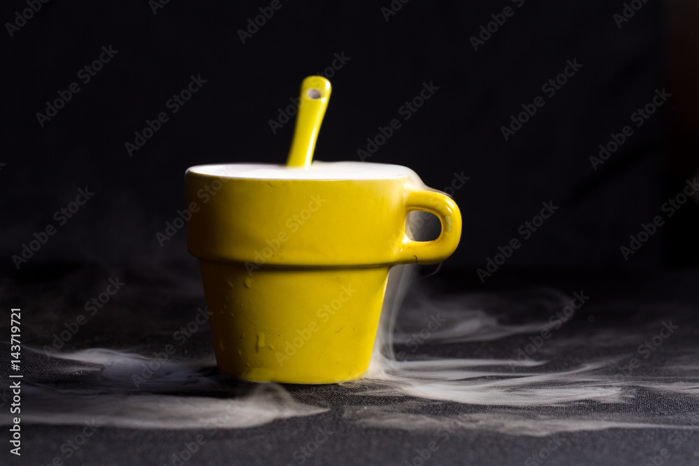 Tazza gialla con cucchiaino con fumo che esce Tazza gialla con cucchiaino con fumo che esce