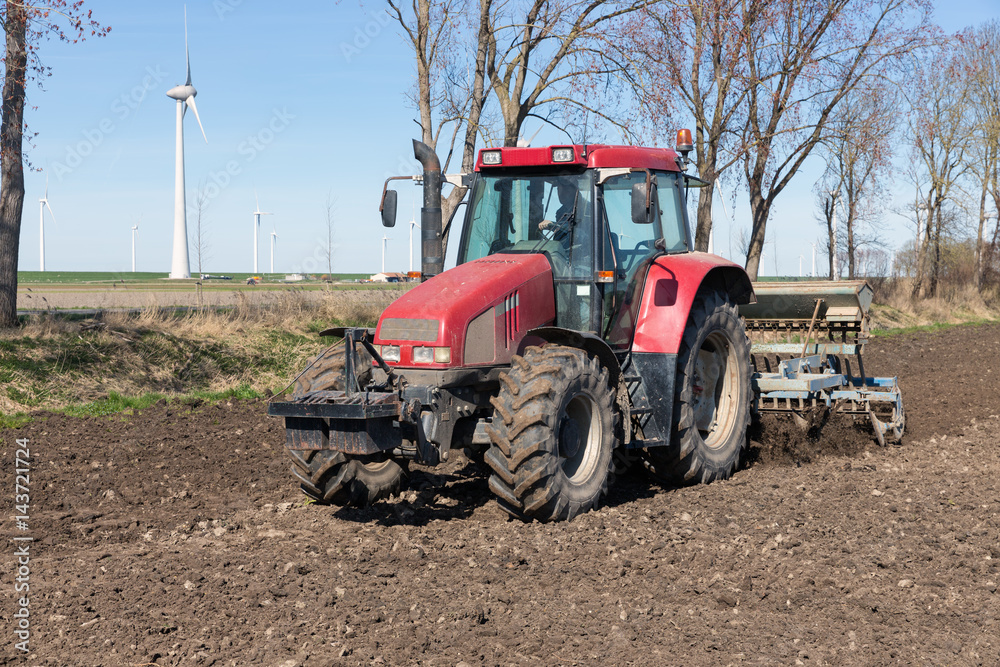 Tractor plough at bare Dutch field in early springtime Tractor plough at bare Dutch field in early springtime