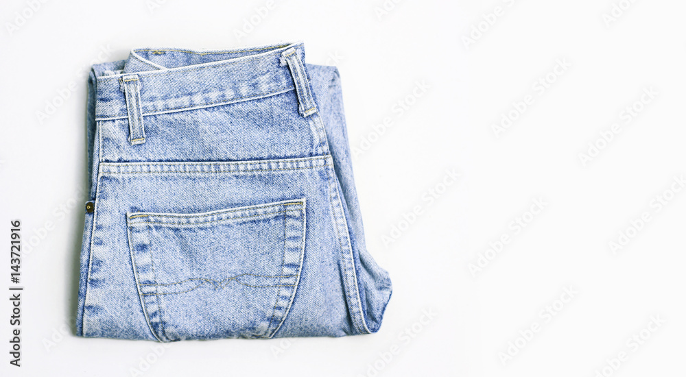 Folded fashionable jeans on a white background Folded fashionable jeans on a white background