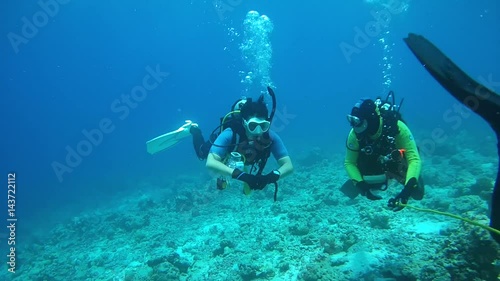 Two scuba diver actively communicate underwater, Indian Ocean, Maldivies
 photo