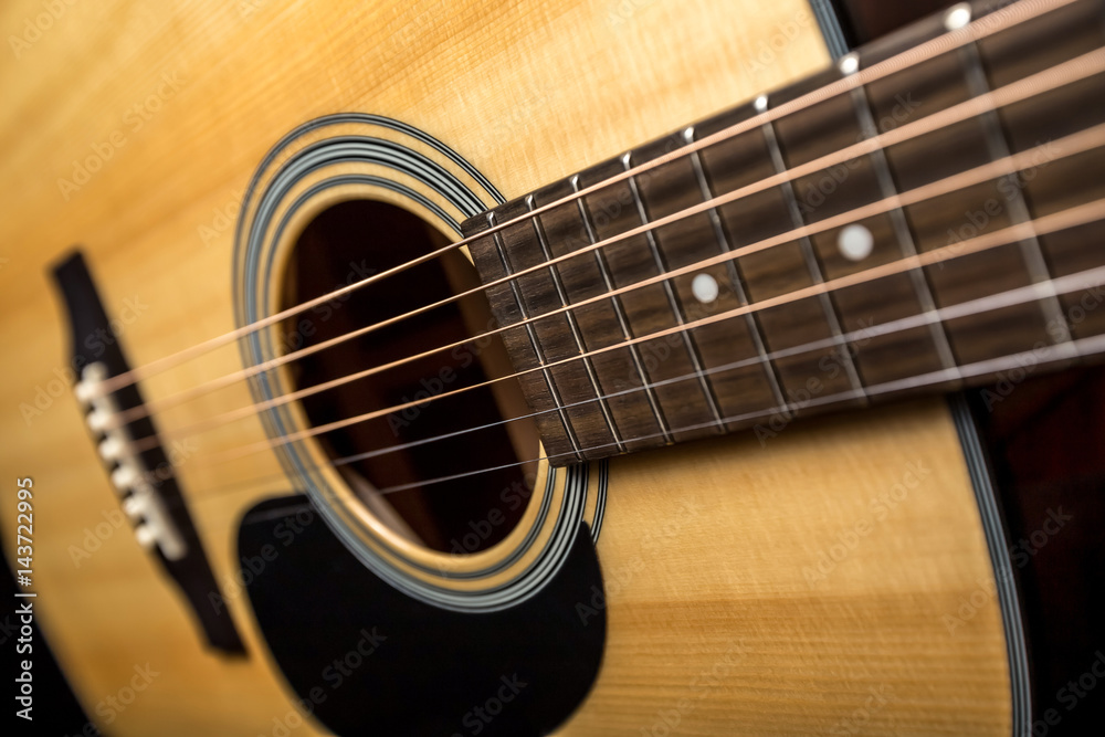 Yellow acoustic wooden guitar on a black background