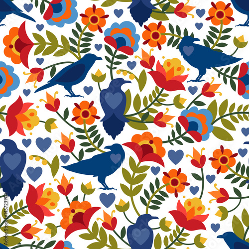 Seamless pattern with raven, symbols of the heart and flowers. Background with flat shapes in blue, green, red, orange and yellow colors. Texture in ethno style. Vector illustration. © Xenia