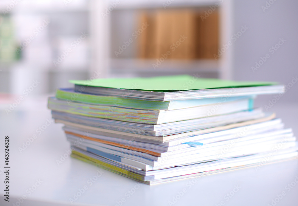 A stack of documentation is on the desktop in the office A stack of documentation is on the desktop in the office
