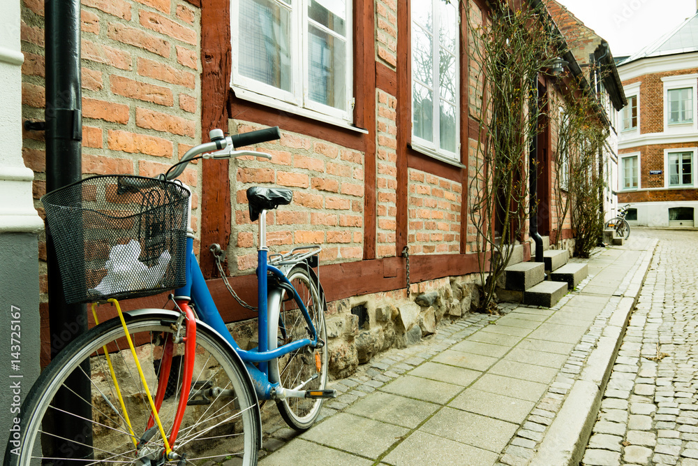 Colorful bike standing against  a wall of an old half timberd house