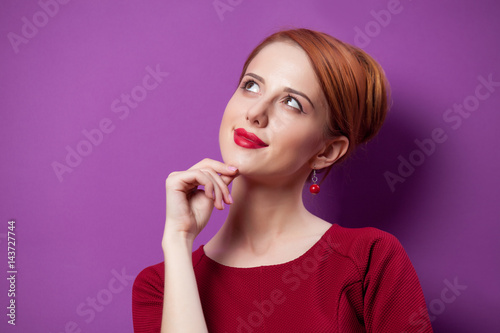 photo of beautiful young woman standing on the wonderful purple studio background