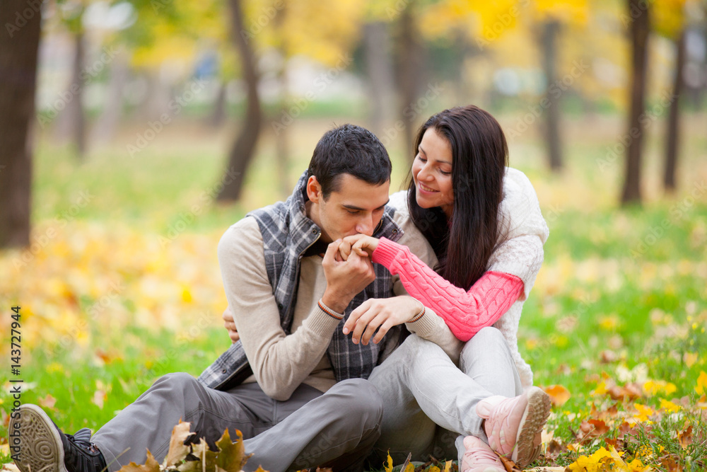 photo of handsome man kissing his woman hand on the wonderful autumn park background photo of handsome man kissing his woman hand on the wonderful autumn park background