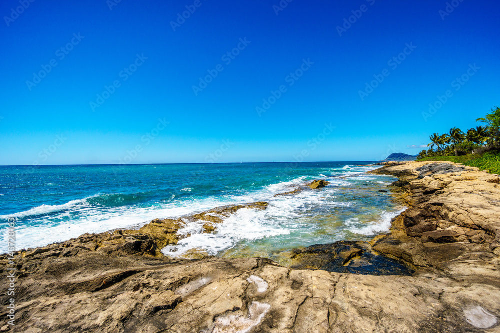 Waves of the Pacific Ocean crashing on the rocks on the shoreline of Ko Olina on the island of Oahu in the island state of Hawaii 