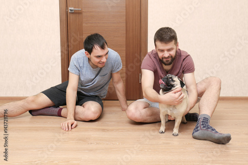Happy gay couple sitting on...