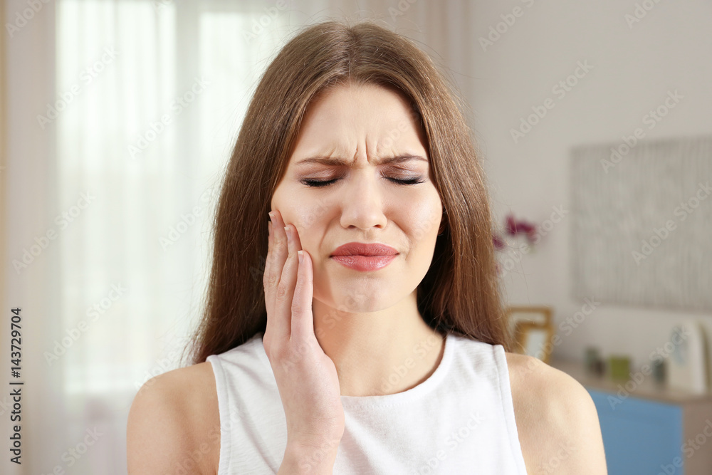 Young woman suffering from toothache at home Young woman suffering from toothache at home
