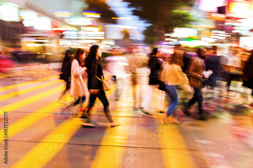 crowds of people crossing a street at night