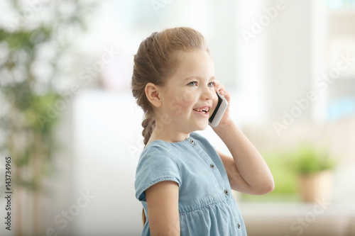 Cute little girl talking by...