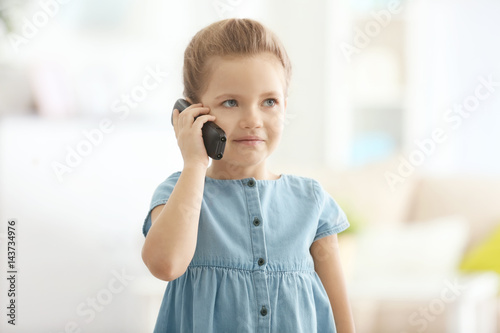 Cute little girl talking by...