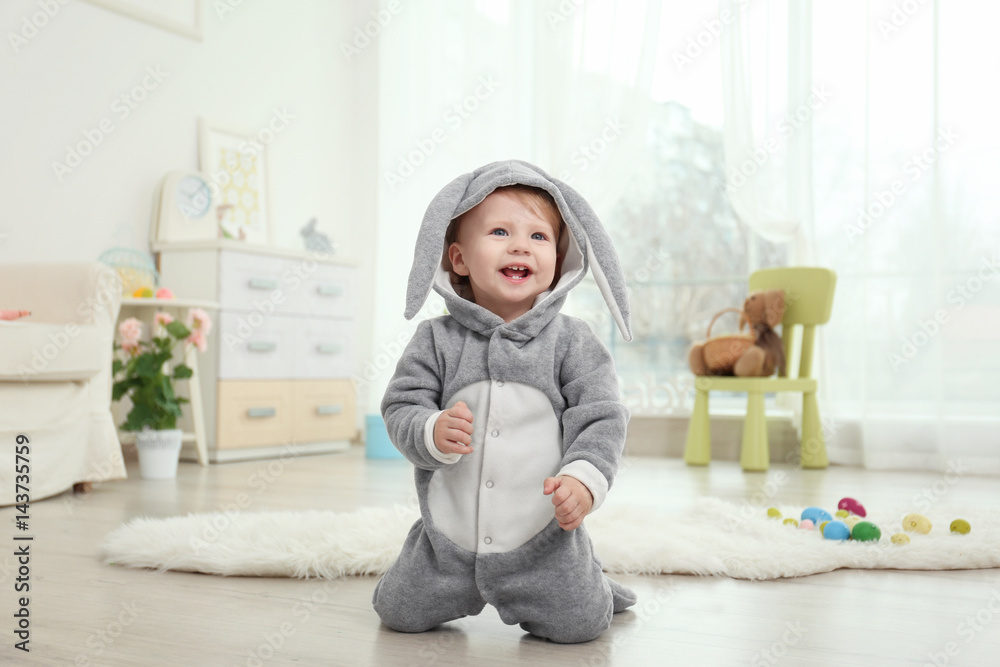 Naklejka premium Cute little baby in bunny costume playing at home