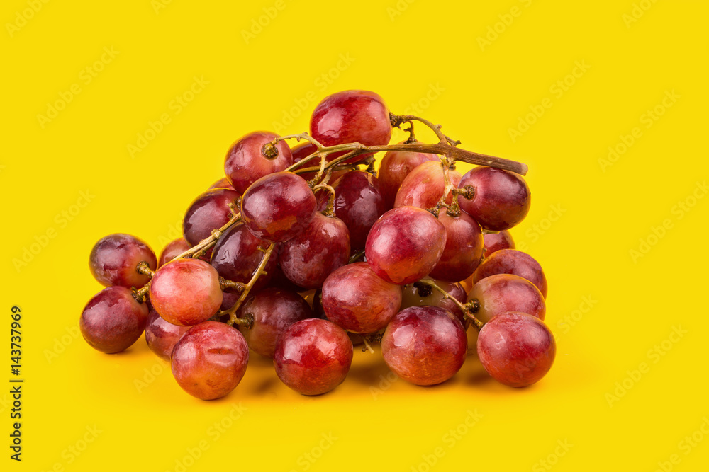 fresh and delicious red grapes isolated on yellow background fresh and delicious red grapes isolated on yellow background