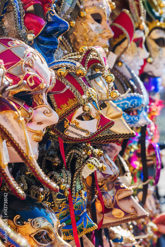 bulk of Venetian masks hanging at a rack