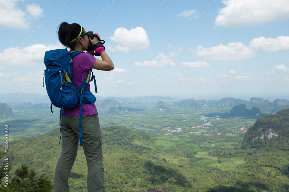 successful woman hiker taking photo hiking on mountain peak