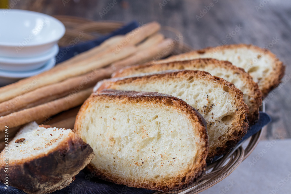 Freshly baked sliced bread on rustic wooden table, close up of brown bread.